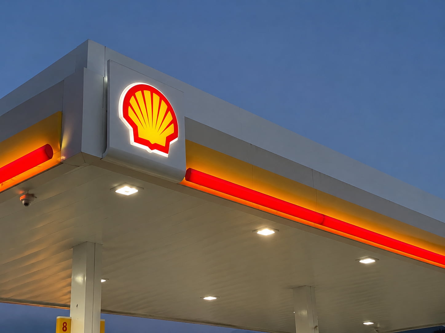 Fuel station canopy fascia sign with illuminated logo and brand colors
