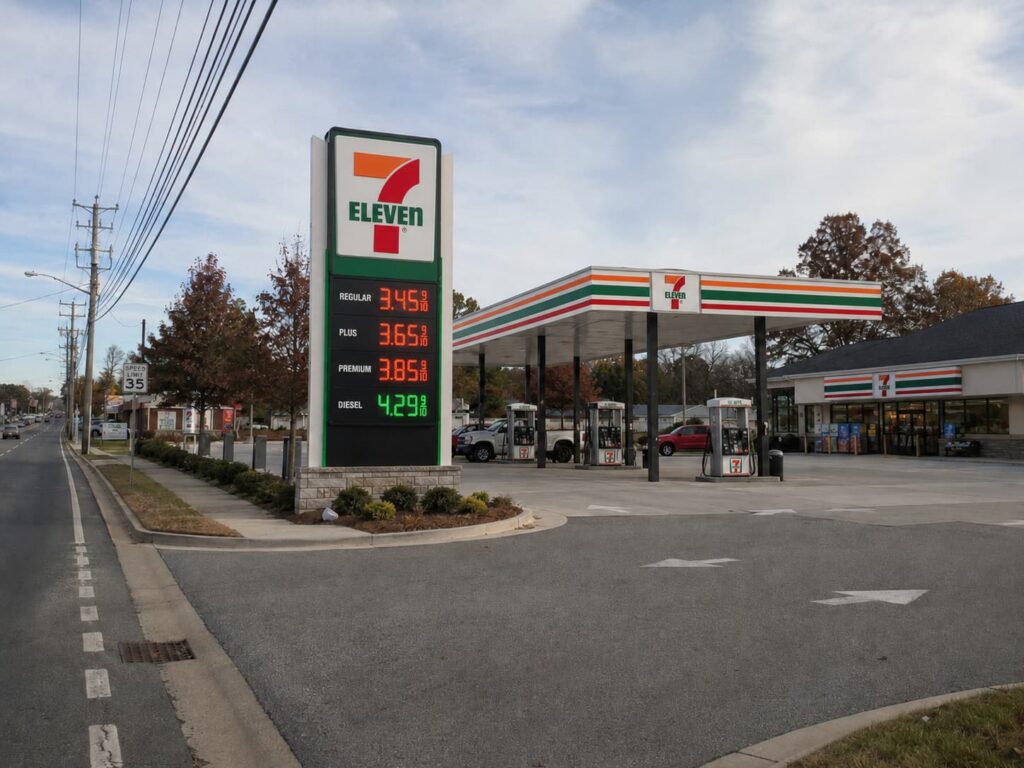 Custom gas station pylon with LED fuel price display viewed from the road