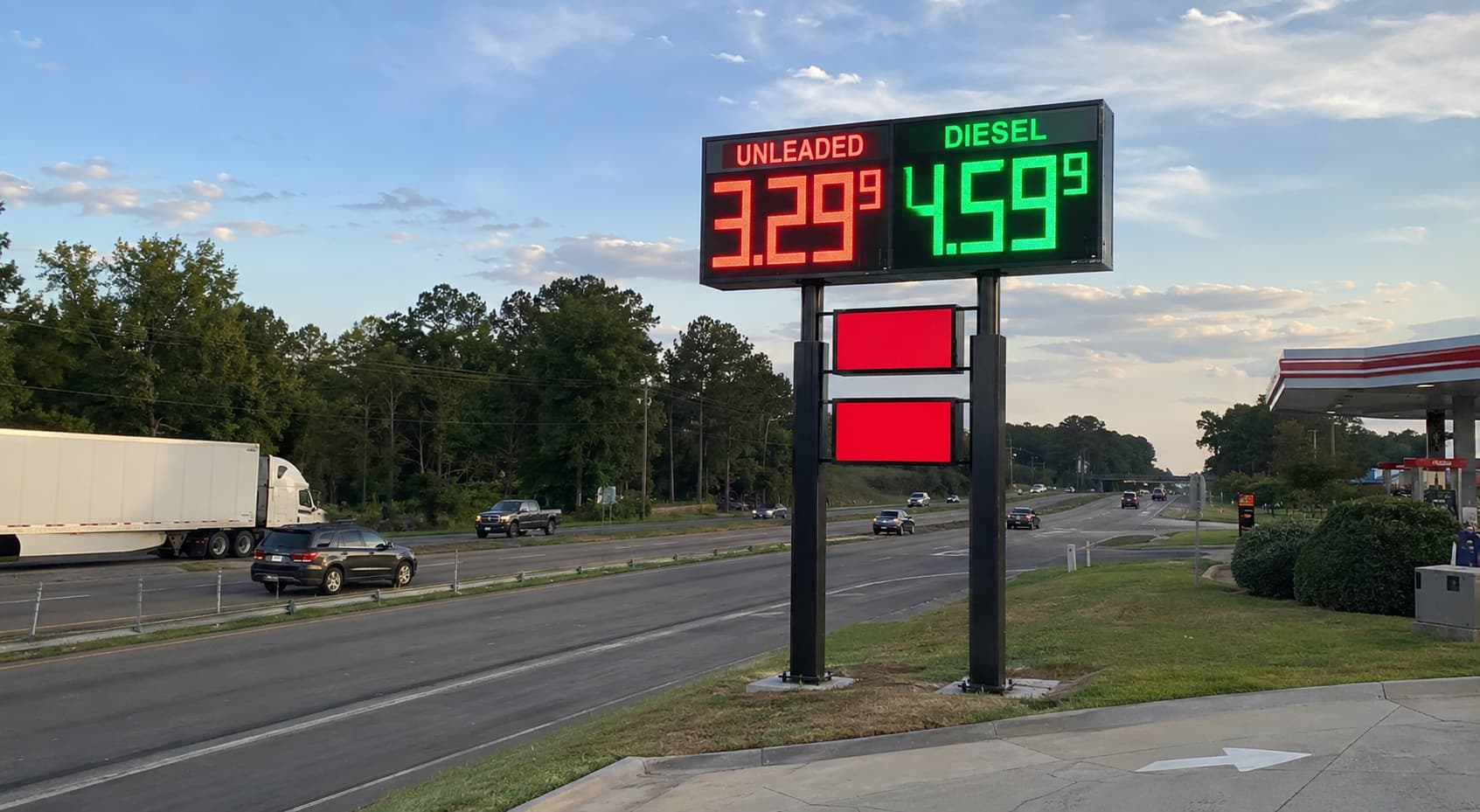 Gas station pylon sign with LED fuel price display viewed from the road