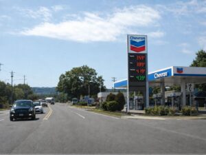 Gasoline price sign with LED fuel prices installed beside a fuel station road