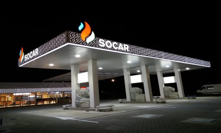 gas canopy with illuminated logos and fascia lighting at night